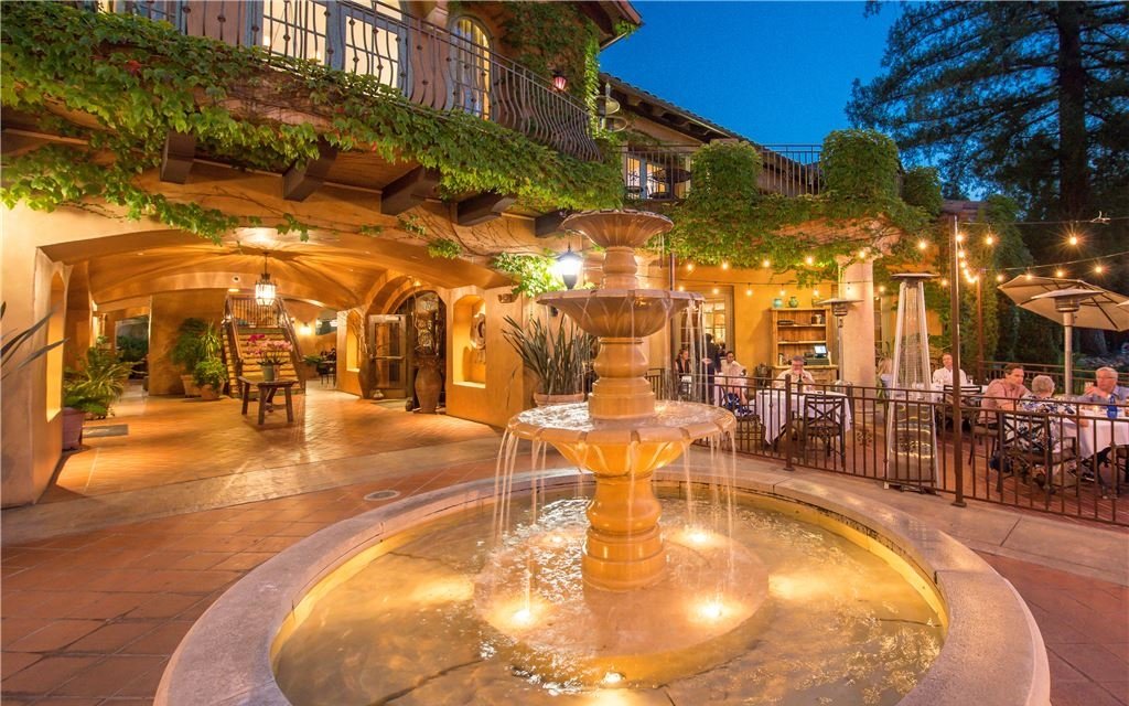 Fountain in outdoor eating space lit up at night