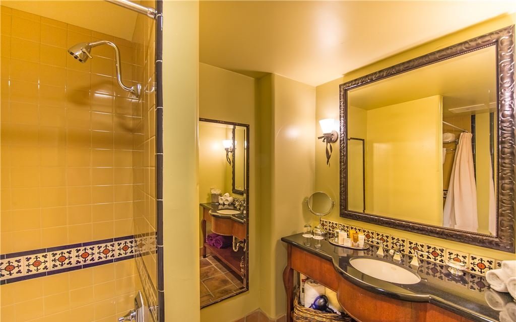 Yellow tiled shower and single-sink countertop