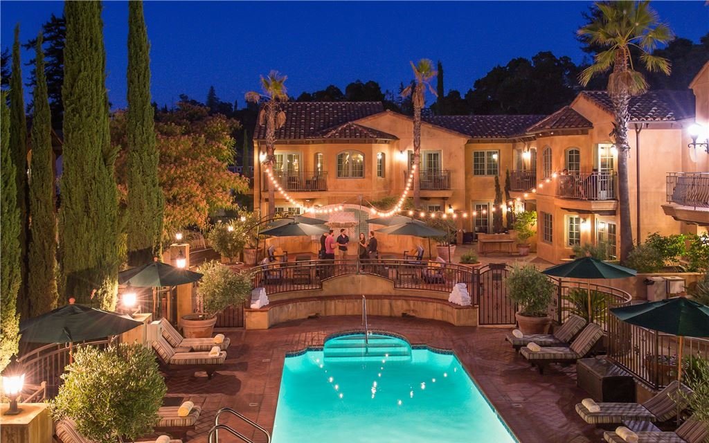 Outdoor pool and patio space lit warmly at night