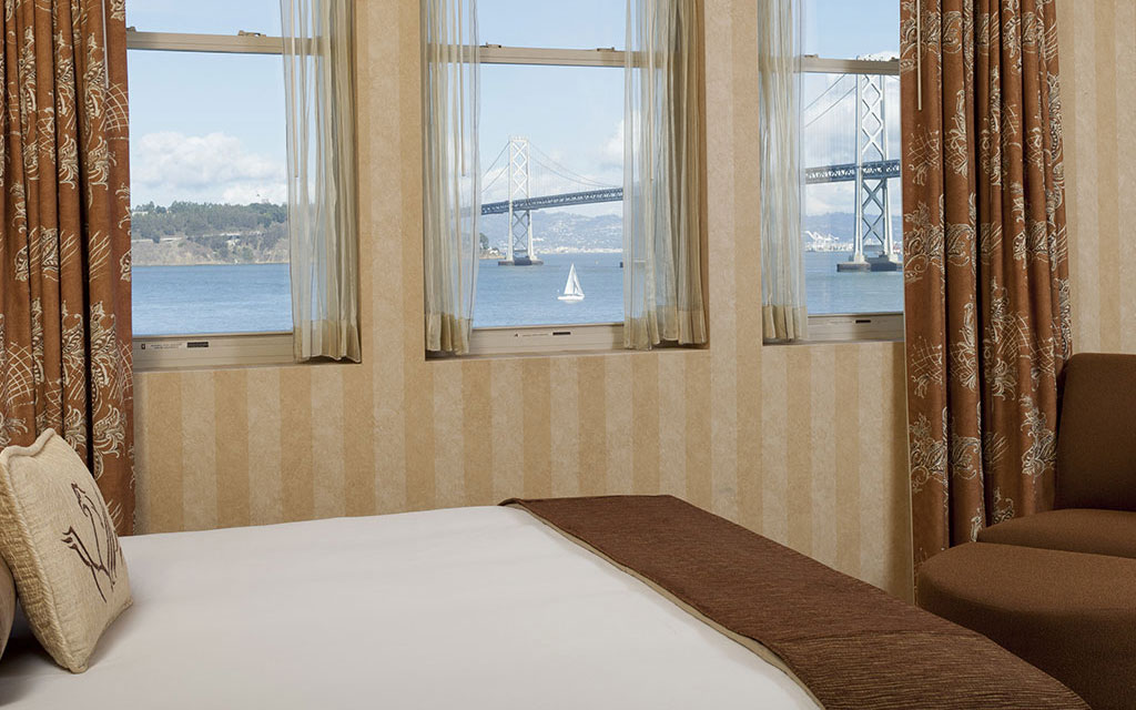 Bedroom with a view of a bay and bridge