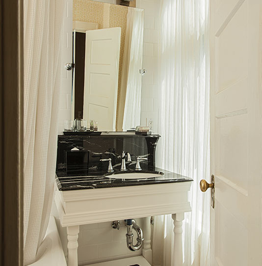 Ornate sink and countertop by a bathtub