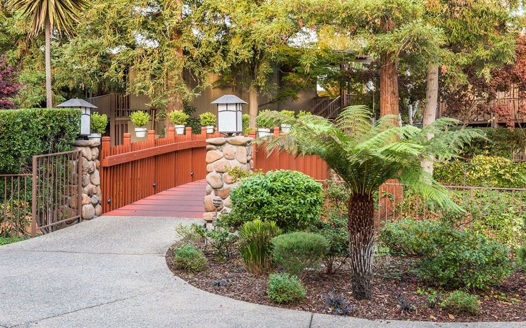 path lined with gardens leads to a bridge