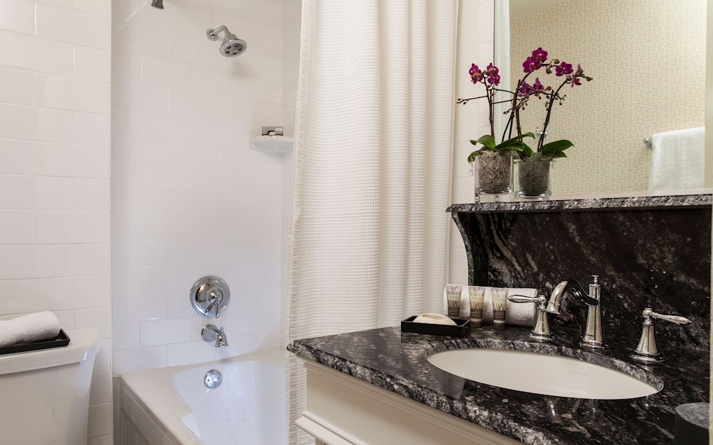 Curtained bathtub with a marble countertop and sink