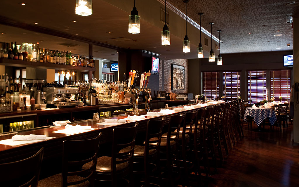 Warmly lit bar lined with barstools