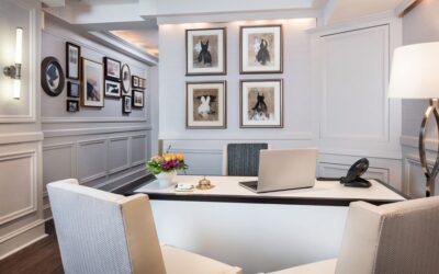 Chairs arranged around a desk in a room with walls covered in paintings