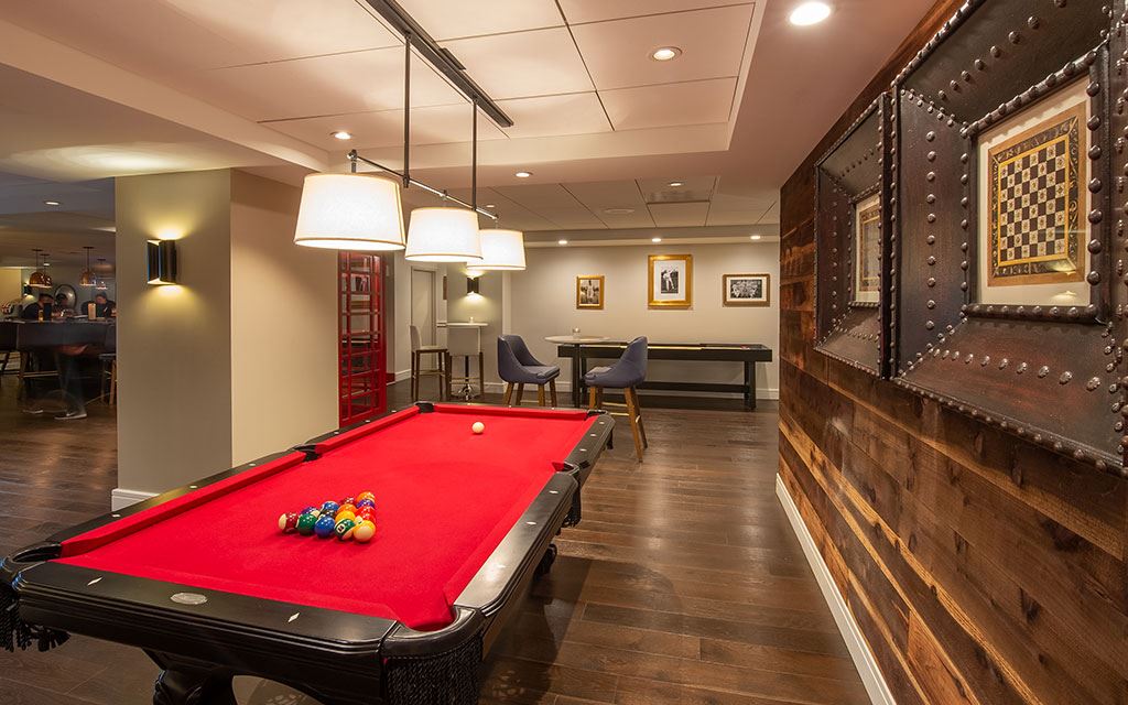 Pool table in the foreground with chairs and tables in the background